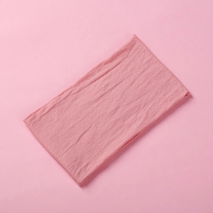 Close-up of pink knitted baby headband showing soft woven texture on flat surface