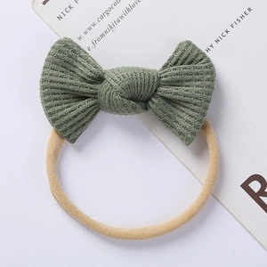 Detail view of olive green waffle knit baby headband with soft nylon bow feature