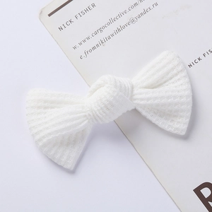 Close-up detail of white waffle knit bow hair clip with premium knitted fabric texture