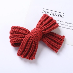 Détail du nœud tricoté rouge foncé avec couture apparente et texture de laine douce