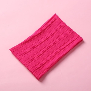 Detailed close-up of knitted baby headband texture featuring jacquard cable patterns