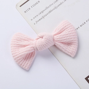 Detailed close-up showing the soft waffle texture of the pink knitted bow hair clip