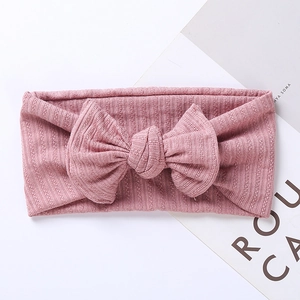 Soft dusty rose ribbed knit baby headband featuring a large matching textured bow
