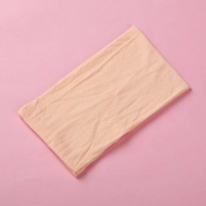 Detail view of ultra-soft light beige nylon fabric texture for baby headband