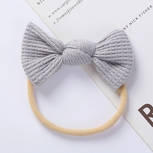 Detail view of the soft grey knit texture and elastic headband on the baby bow