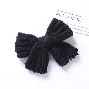 Gros plan sur la barrette nœud en tricot noir avec texture en laine sur carte blanche