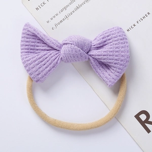 Close-up of a purple waffle knit bow headband with a soft and stretchy seamless nylon band