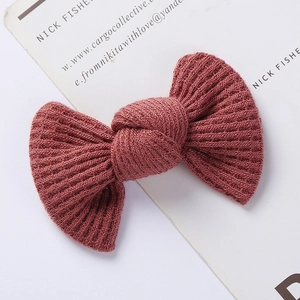 Close-up of deep pink waffle knit bow hair clip with thick texture and knot detail