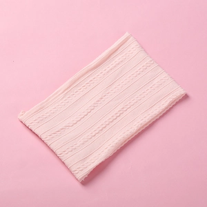Close-up of baby pink jacquard nylon headband featuring soft knit cable pattern texture