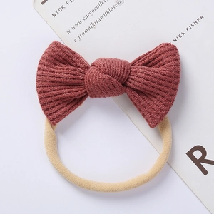 Close-up of baby waffle knit bow headband in brick red with soft elastic band