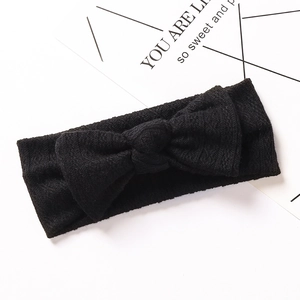 Gros plan d'un bandeau bébé en maille jacquard noire avec un grand nœud élastique