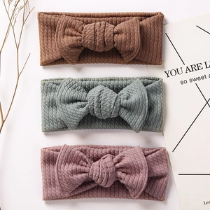 Three-piece set of waffle knit baby headbands with large bows in neutral earth tones