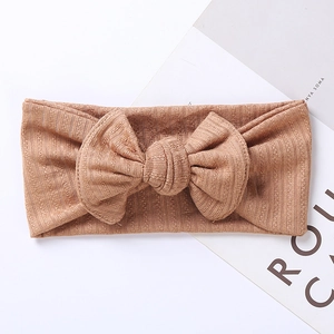 Close-up of ribbed texture and large bow on khaki knit headband for babies