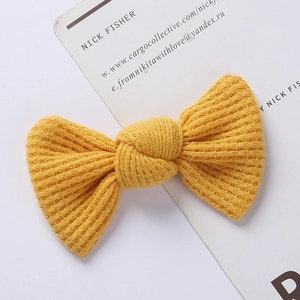 Detailed shot of yellow knitted bow hair clip featuring soft waffle knit texture