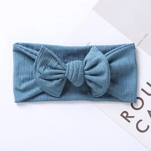 Detail of soft ribbed knit texture and large bow on a dusty blue infant headband