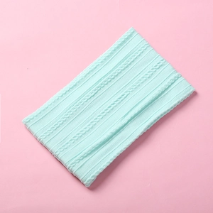 Detail shot of mint green jacquard nylon baby headband with soft cable knit pattern