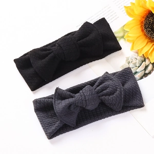 Close-up of soft ribbed knit baby headbands with large bows in black and grey