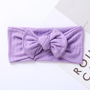 Detailed texture of purple ribbed knit headband with a large bow for infants