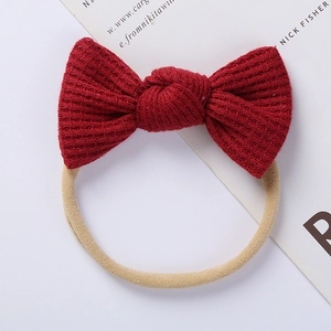 Detailed macro of red waffle knit bow on elastic nylon headband for infants and babies