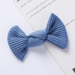 Detailed view of light blue waffle-knit texture and soft fabric on the bow hair clip