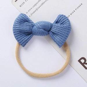Detail view showing blue waffle knit texture and soft nylon band on a baby bow headband