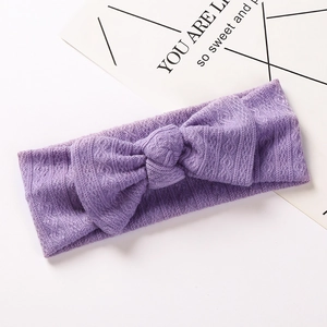 Détail du bandeau bébé côtelé violet clair avec un grand nœud en tricot jacquard