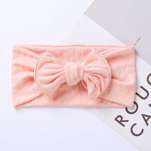 Close-up of pink jacquard ribbed knit baby headband with a large decorative bow