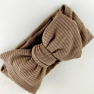 Macro shot of brown ribbed knit texture and wide knot detail on baby headband