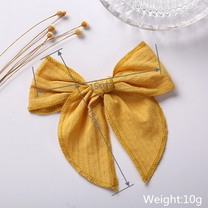 Detail of 6-inch bright yellow textured cotton bow clip with 15cm size measurement