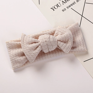 Detail showing soft waffle texture and oversized bow on this light pink baby headband