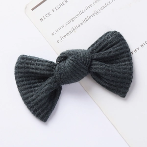 Close-up of dark grey waffle knit bow clip with textured fabric for kids hair