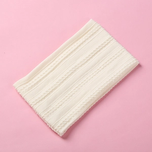 Detail of soft white cable knit nylon baby headband texture on pink background