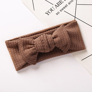 Detailed texture of brown waffle knit baby headband featuring a large central bow