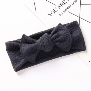 Close-up of baby ribbed knit headband in dark gray with a large bow detail