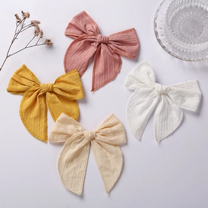 Detail view of 6 inch jacquard cotton bow hair clips in pink, yellow, white, and apricot