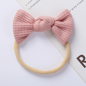 Detailed close-up of pink waffle knit bow headband with elastic seamless nylon band