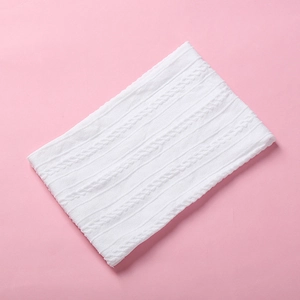 Detailed close-up of white cable knit nylon baby headband with soft braided texture