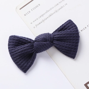 Detailed macro view of navy blue waffle knit texture on a handmade bow hair clip