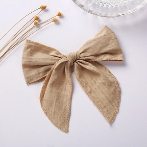 Detail of 6 inch jacquard cotton bow hair clip with textured fabric and long ribbons
