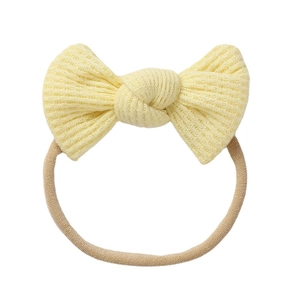 Pale yellow waffle knit baby headband with a handmade bow and elastic band