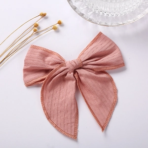 Detail of soft pink textured cotton hair bow with fine jacquard weave patterns