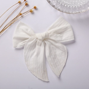 Detail view of 6 inches white jacquard cotton bow hairpin with elegant textures