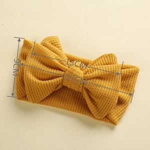 Detailed macro view showing the waffle fabric texture and size dimensions of yellow baby headband
