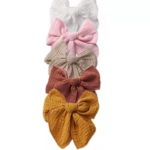 Set of five muslin cotton bow clips in assorted soft colors with natural crinkle texture