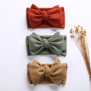 Detailed waffle texture of handmade large bow baby headbands in earthy natural tones