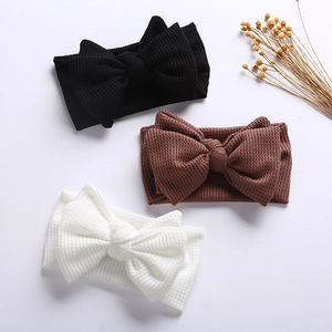 Three infant waffle bows in black, brown and white on a clean white backdrop