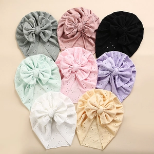 Set of eight soft cotton baby turban hats with large bows and delicate eyelet embroidery
