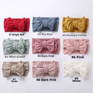 Detail showing nine colors of ribbed knit baby headbands with oversized double bows