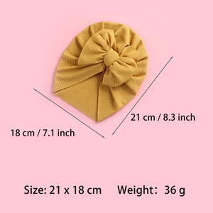 Detail view of yellow ribbed knit baby turban showing dimensions 21 x 18 cm and 36g weight