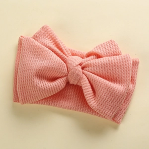 Close-up of pink waffle knit texture and handmade large bow detail on baby headband